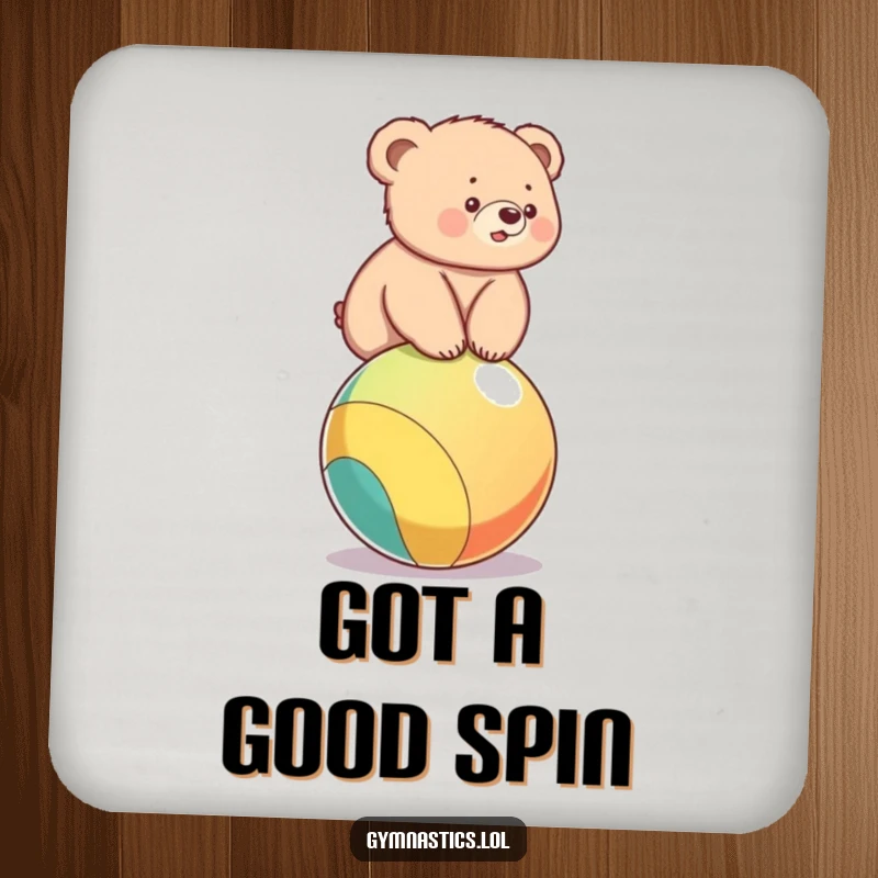 Funny drink coaster with a bear cub balancing on a colorful ball, adding humor to surface protection.