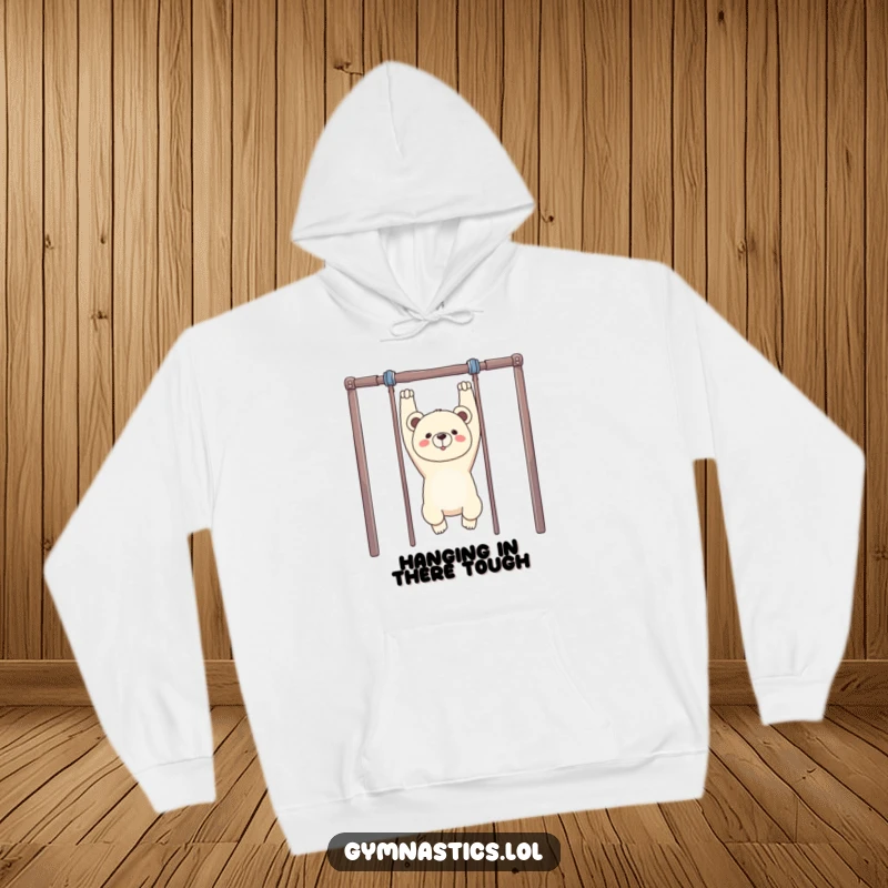 Funny Bear Gymnastics Hoodie: A proud bear hangs upside down from uneven bars, offering a humorous and cozy addition to any wardrobe.